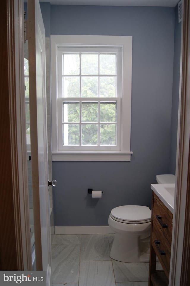 4305 Bradley Ln, Chevy Chase, MD 20815 - bathroom with vanity, toilet, a tub to relax in, and baseboards
