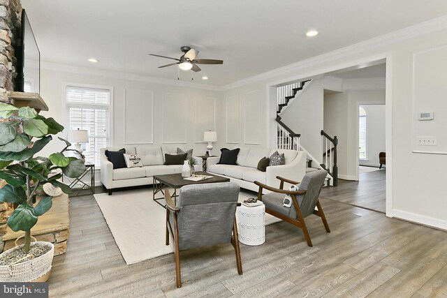 23219 Christopher Thomas Ln, Brambleton, VA 20148 - living area featuring ceiling fan, ornamental molding, healthy amount of natural light, stairway, and wood finished floors