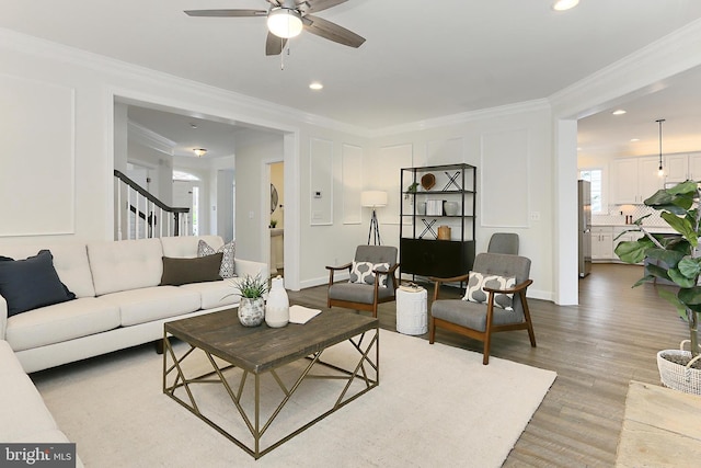 23219 Christopher Thomas Ln, Brambleton, VA 20148 - living area featuring ceiling fan, light wood-type flooring, ornamental molding, recessed lighting, and stairway