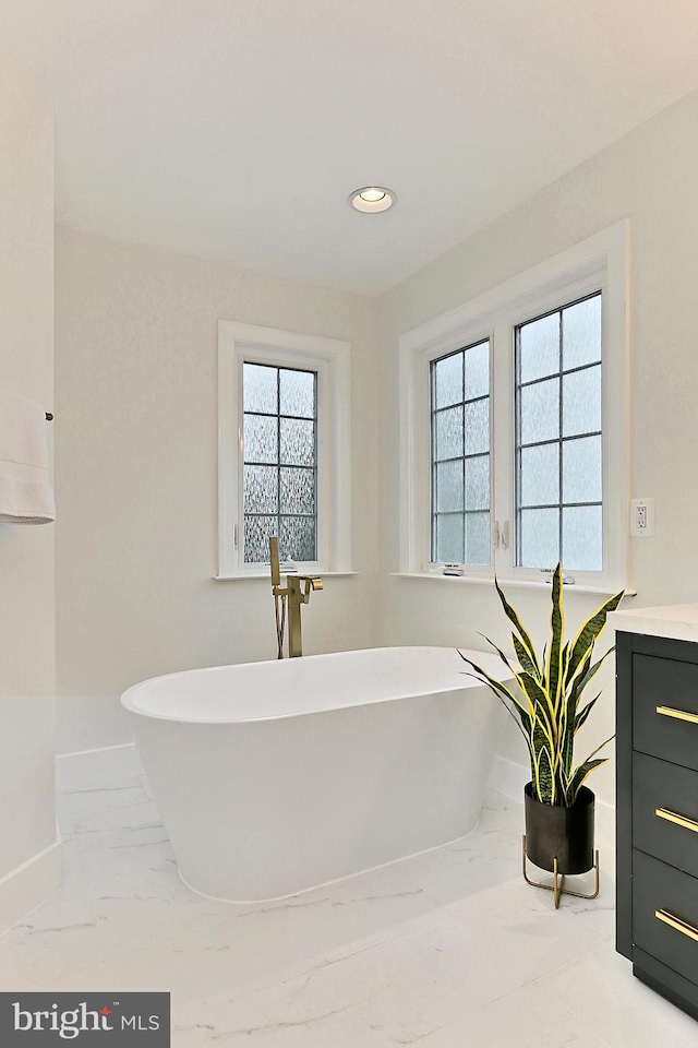 23219 Christopher Thomas Ln, Brambleton, VA 20148 - bathroom with marble finish flooring, a freestanding tub, recessed lighting, and vanity