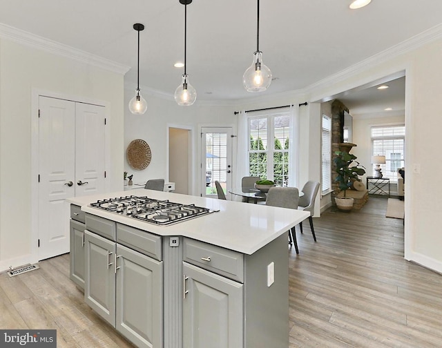 23219 Christopher Thomas Ln, Brambleton, VA 20148 - kitchen with stainless steel gas stovetop, ornamental molding, light wood-type flooring, a center island, and recessed lighting