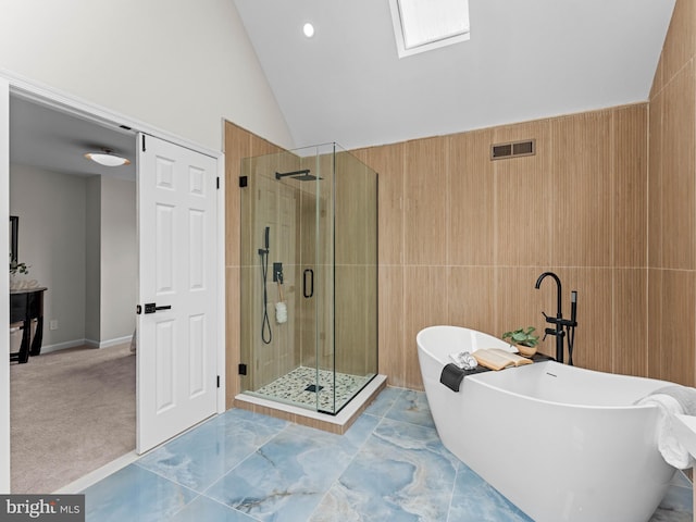 44 Wilson Dr, Sicklerville, NJ 08081 - bathroom featuring a stall shower, a freestanding tub, lofted ceiling, a skylight, and tile walls