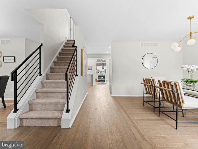 44 Wilson Dr, Sicklerville, NJ 08081 - stairs featuring wood finished floors, baseboards, and a chandelier