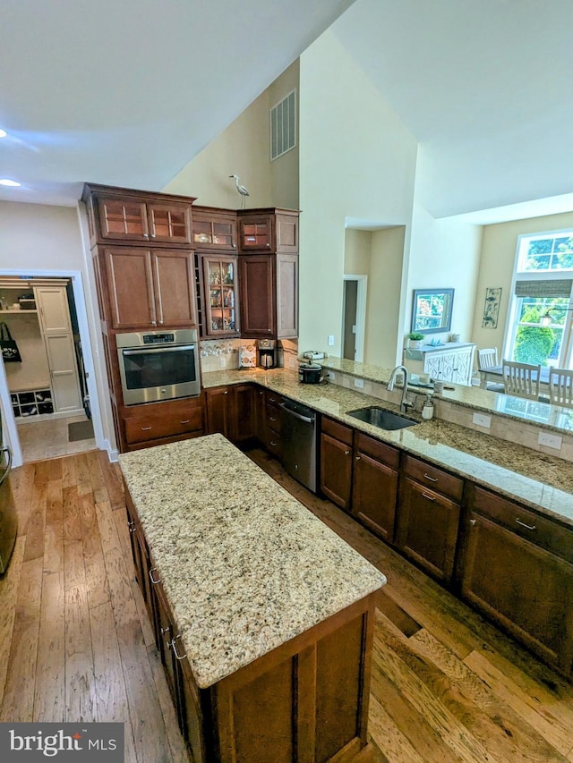 35516 Hedgerow Ln, Rehoboth Beach, DE 19971 - kitchen with appliances with stainless steel finishes, a sink, light wood finished floors, light stone countertops, and high vaulted ceiling