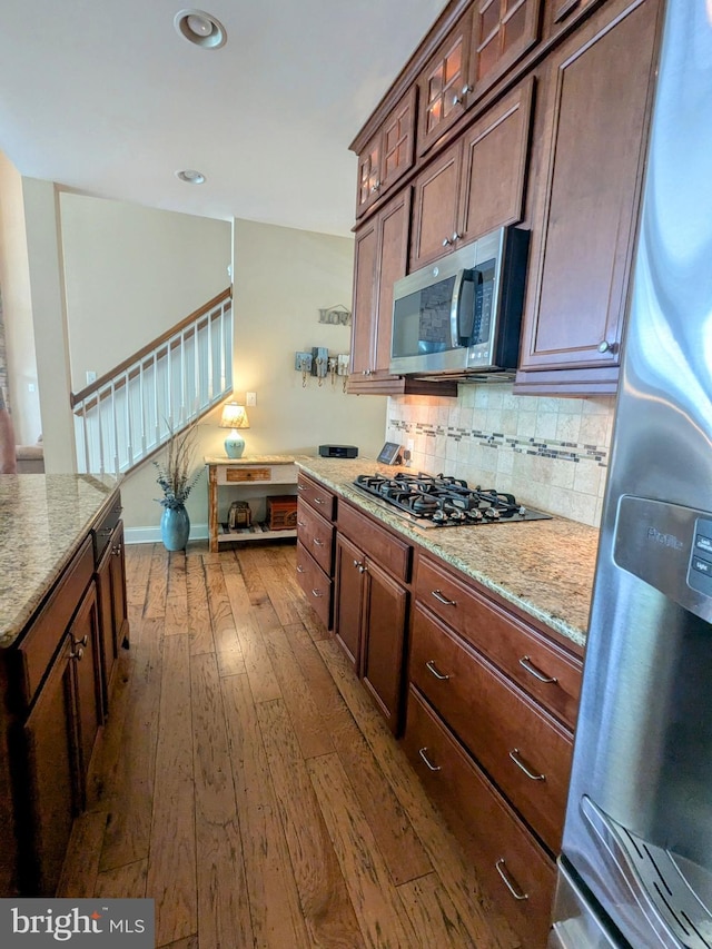 35516 Hedgerow Ln, Rehoboth Beach, DE 19971 - kitchen with appliances with stainless steel finishes, dark wood finished floors, backsplash, light stone countertops, and recessed lighting