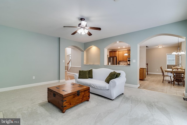 6422 Hard Bargain Cir, Indian Head, MD 20640 - living room featuring light carpet, arched walkways, a ceiling fan, and baseboards