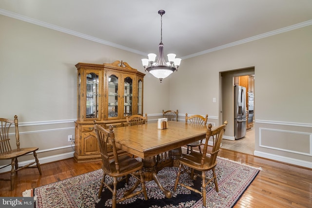 6422 Hard Bargain Cir, Indian Head, MD 20640 - dining area with crown molding, a chandelier, and light wood-type flooring