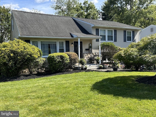 228 Woodlawn Dr, Lansdale, PA 19446 - split level home with a front lawn, roof with shingles, and covered porch