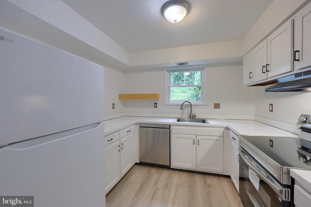 1134 Fox Run, Reading, PA 19606 - kitchen with stainless steel appliances, a sink, under cabinet range hood, light wood-type flooring, and white cabinets
