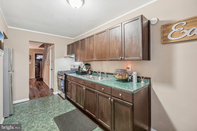 904 N Rosedale St, Baltimore, MD 21216 - kitchen with gas range, a sink, under cabinet range hood, baseboards, and ornamental molding