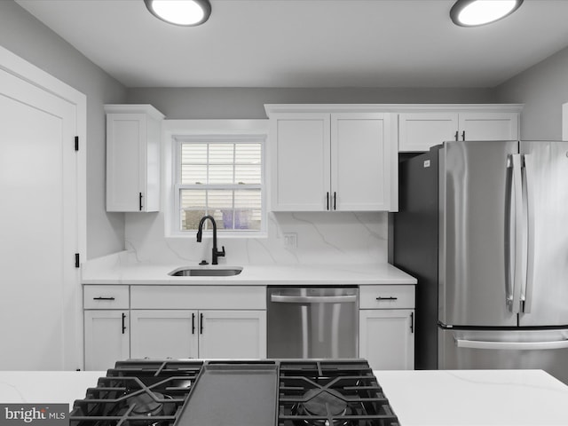 5105 11th St S, Arlington, VA 22204 - kitchen featuring appliances with stainless steel finishes, a sink, white cabinets, and tasteful backsplash