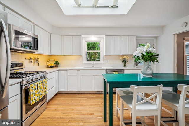 3117 Port Way, Annapolis, MD 21403 - kitchen with stainless steel appliances, a sink, light wood-style floors, and white cabinetry