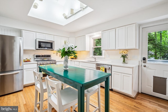 3117 Port Way, Annapolis, MD 21403 - kitchen with stainless steel appliances, light countertops, white cabinetry, light wood-style flooring, and tasteful backsplash
