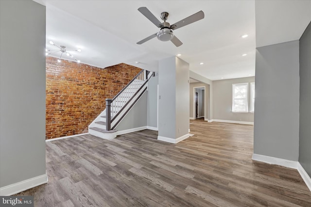 405 N Loudon Ave, Baltimore, MD 21229 - unfurnished living room with brick wall, stairs, wood finished floors, baseboards, and ceiling fan