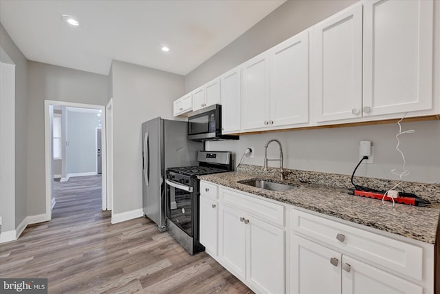 405 N Loudon Ave, Baltimore, MD 21229 - kitchen with appliances with stainless steel finishes, a sink, stone counters, light wood-style floors, and white cabinets