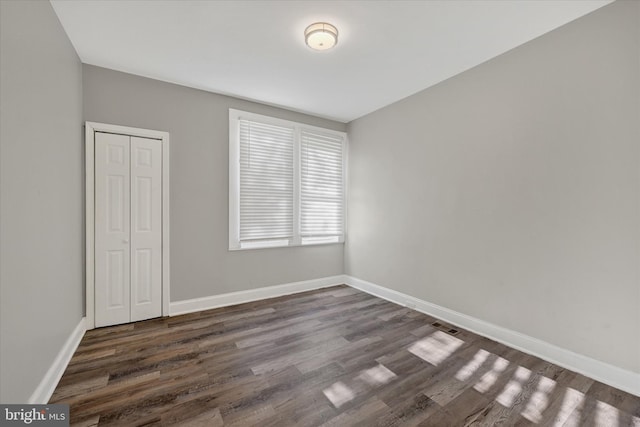 405 N Loudon Ave, Baltimore, MD 21229 - unfurnished bedroom with dark wood-style flooring, a closet, and baseboards