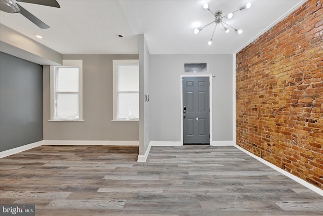 405 N Loudon Ave, Baltimore, MD 21229 - entrance foyer with brick wall, wood finished floors, a ceiling fan, baseboards, and a chandelier