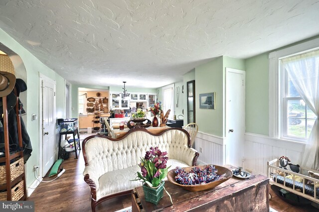 2241 Craley Rd, Windsor, PA 17366 - living area featuring dark wood-style floors, a wainscoted wall, and a textured ceiling