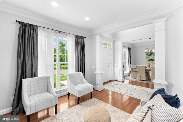 41311 Silverside Dr, Leesburg, VA 20175 - living area featuring decorative columns, ornamental molding, wood finished floors, baseboards, and a chandelier