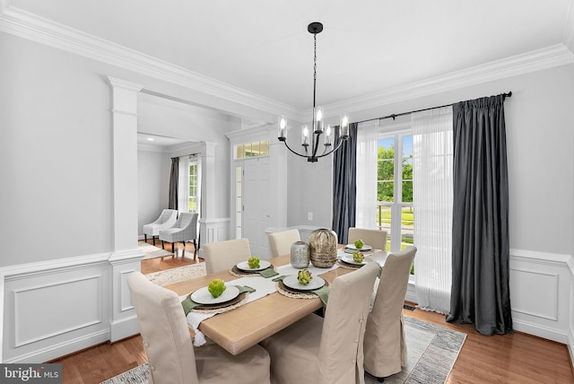 41311 Silverside Dr, Leesburg, VA 20175 - dining area featuring healthy amount of natural light, crown molding, a chandelier, a wainscoted wall, and light wood-style floors