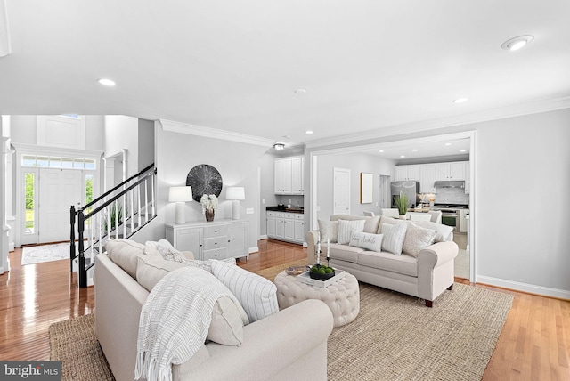 41311 Silverside Dr, Leesburg, VA 20175 - living area with baseboards, ornamental molding, light wood finished floors, stairs, and recessed lighting