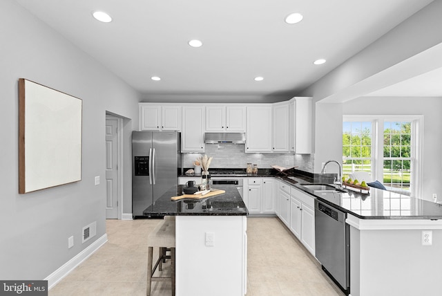 41311 Silverside Dr, Leesburg, VA 20175 - kitchen featuring stainless steel appliances, under cabinet range hood, a sink, recessed lighting, and white cabinetry