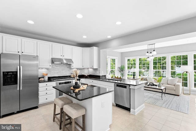 41311 Silverside Dr, Leesburg, VA 20175 - kitchen featuring appliances with stainless steel finishes, under cabinet range hood, a sink, a peninsula, and recessed lighting