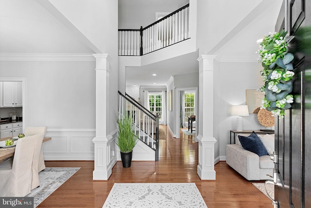 41311 Silverside Dr, Leesburg, VA 20175 - foyer entrance featuring decorative columns, stairs, wood finished floors, a high ceiling, and crown molding