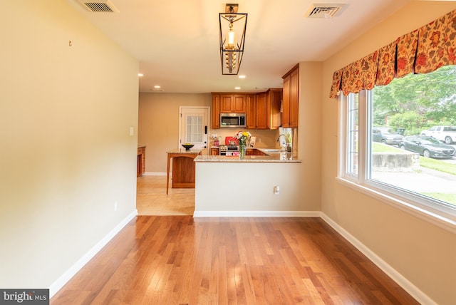 724 E Curtin St, Bellefonte, PA 16823 - kitchen with stainless steel appliances, brown cabinets, baseboards, light wood finished floors, and recessed lighting
