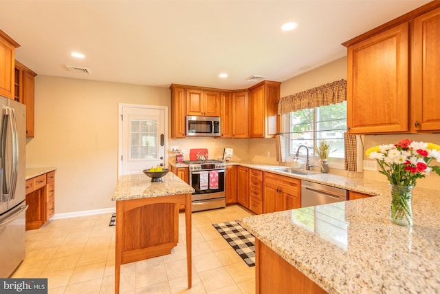 724 E Curtin St, Bellefonte, PA 16823 - kitchen with stainless steel appliances, a sink, light stone countertops, recessed lighting, and brown cabinets