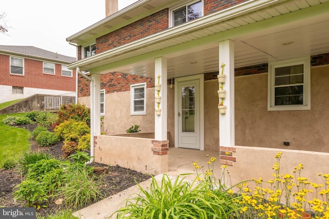 724 E Curtin St, Bellefonte, PA 16823 - property entrance with covered porch, stucco siding, and brick siding