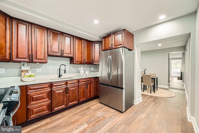 1402 W Lombard St, Baltimore, MD 21223 - kitchen with freestanding refrigerator, a sink, light countertops, light wood-style flooring, and recessed lighting