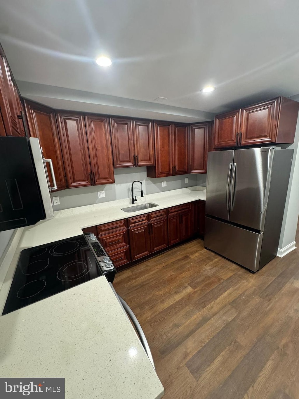 1402 W Lombard St, Baltimore, MD 21223 - kitchen featuring freestanding refrigerator, a sink, light countertops, dark wood finished floors, and electric range