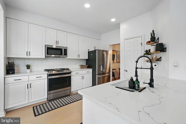 47686 Sandbank Sq, Sterling, VA 20165 - kitchen featuring stainless steel appliances, white cabinetry, decorative backsplash, recessed lighting, and light stone counters