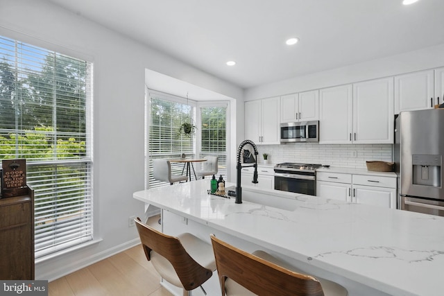 47686 Sandbank Sq, Sterling, VA 20165 - kitchen featuring appliances with stainless steel finishes, a sink, white cabinets, decorative backsplash, and recessed lighting
