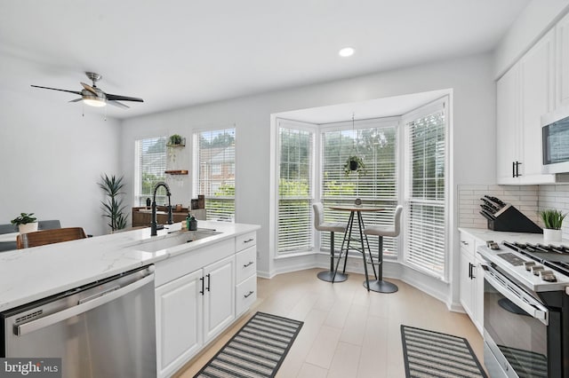 47686 Sandbank Sq, Sterling, VA 20165 - kitchen featuring appliances with stainless steel finishes, a sink, plenty of natural light, white cabinets, and recessed lighting