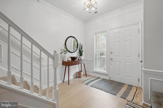 47686 Sandbank Sq, Sterling, VA 20165 - entrance foyer with stairs, a decorative wall, ornamental molding, light wood-style floors, and a wainscoted wall