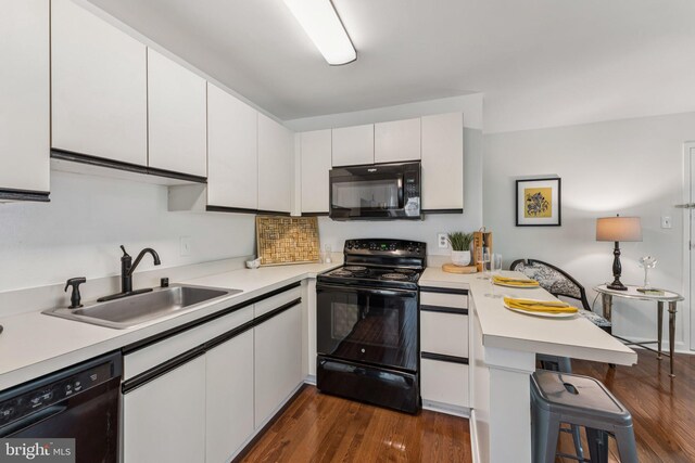 304 Duncan Ave Unit F, Alexandria, VA 22301 - kitchen featuring black appliances, a peninsula, white cabinetry, light countertops, and dark wood-style floors