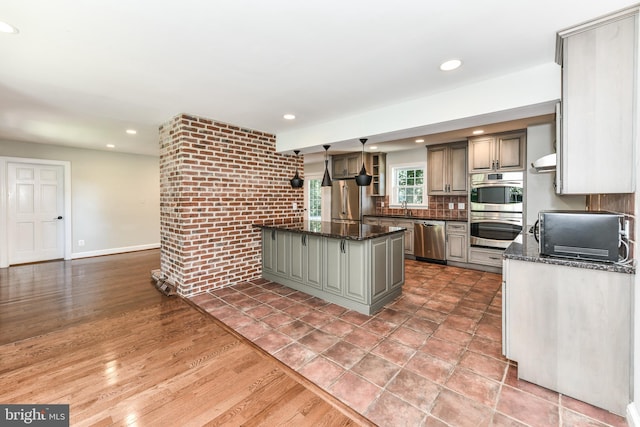 8358 Alvord St, Mclean, VA 22102 - kitchen with appliances with stainless steel finishes, ventilation hood, recessed lighting, a kitchen island, and baseboards