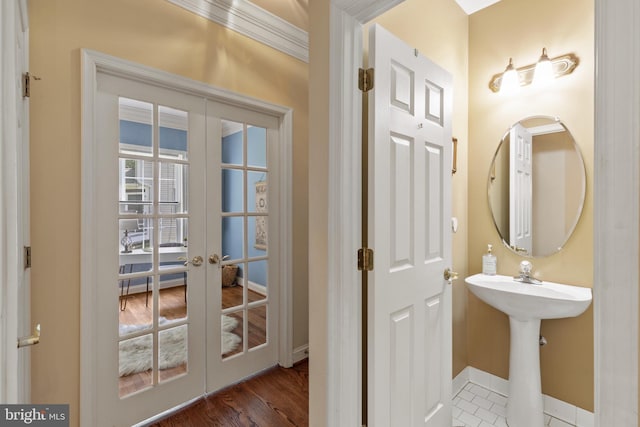 2121 Chaucer Way, Woodstock, MD 21163 - bathroom featuring french doors, baseboards, ornamental molding, a sink, and wood finished floors