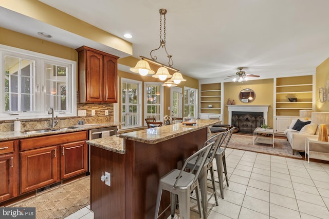 2121 Chaucer Way, Woodstock, MD 21163 - kitchen featuring a sink, light tile patterned floors, a breakfast bar, a ceiling fan, and light stone countertops