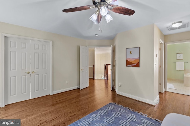2121 Chaucer Way, Woodstock, MD 21163 - bedroom featuring wood finished floors, baseboards, a ceiling fan, a closet, and ensuite bath