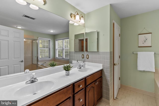 2121 Chaucer Way, Woodstock, MD 21163 - bathroom featuring a bath, double vanity, tile patterned floors, an enclosed shower, and tile walls