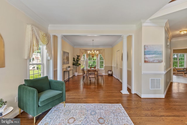 2121 Chaucer Way, Woodstock, MD 21163 - living room with ornate columns, a chandelier, wood finished floors, ornamental molding, and baseboards