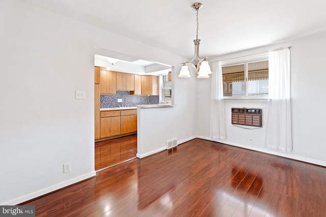 7155 Erdrick St, Philadelphia, PA 19135 - unfurnished dining area featuring dark wood-style floors, a chandelier, baseboards, and heating unit