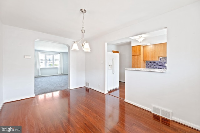 7155 Erdrick St, Philadelphia, PA 19135 - unfurnished room with arched walkways, dark wood-type flooring, baseboards, and a chandelier