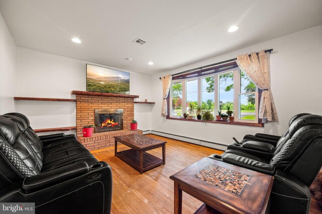 2460 Mill Rd, Quakertown, PA 18951 - living area with baseboard heating, wood finished floors, a brick fireplace, and recessed lighting
