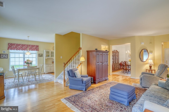 636 Poets Way, Middletown, DE 19709 - living area featuring stairs, wood finished floors, a chandelier, and baseboards
