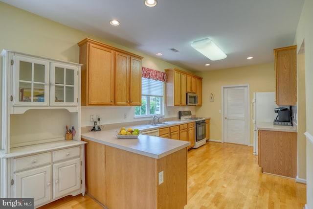 636 Poets Way, Middletown, DE 19709 - kitchen with white appliances, a sink, light countertops, light wood-style floors, and a peninsula
