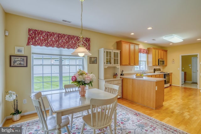 636 Poets Way, Middletown, DE 19709 - kitchen featuring white range with gas cooktop, stainless steel microwave, a peninsula, a sink, and light countertops